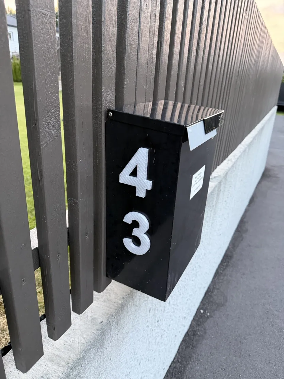 3D-printet husnummer 43 i hvitt på svart postkasse