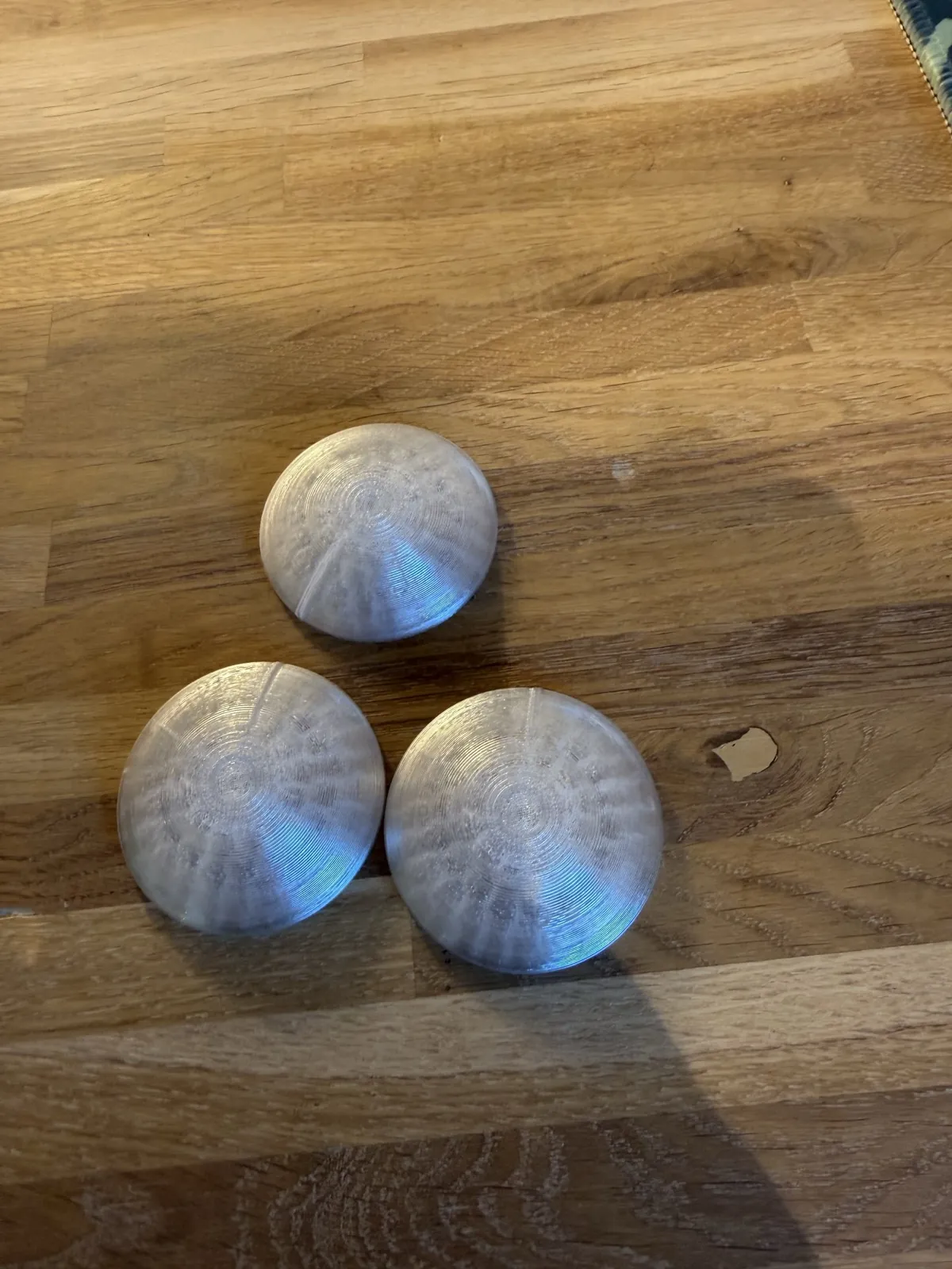 3D-printede krukkeføtter i transparent plast på et tregulv